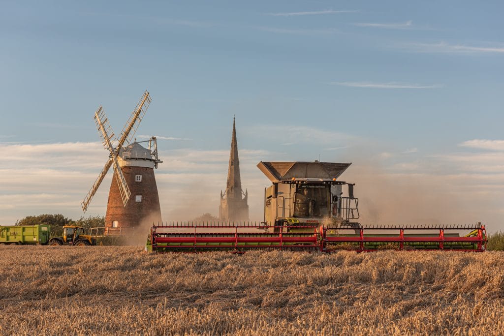_DSC2381 Thaxted windmill with combine harvester working in foreground